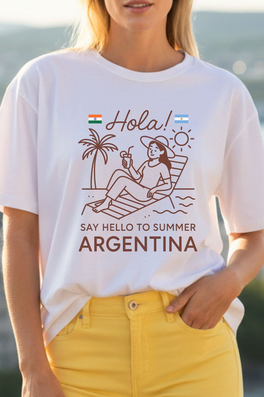 Close up of a woman wearing a white t-shirt with a summer-themed design and text, standing by a body of water.