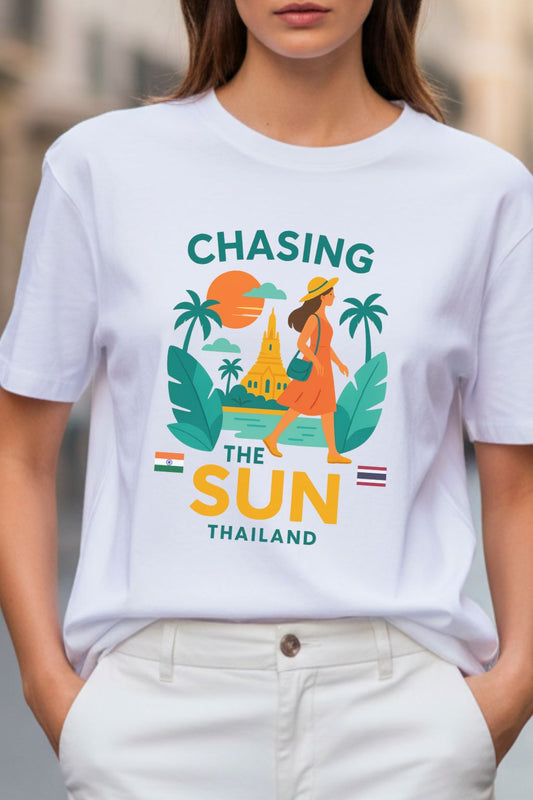 close up of a white oversized t-shirt with 'Chasing the Sun Thailand' graphic worn by a person.