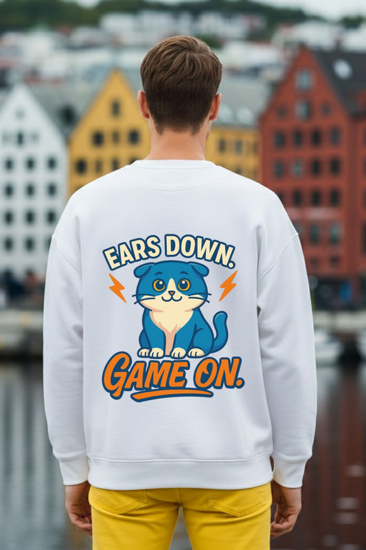 back view of a man wearing a white oversized sweatshirt with a cat graphic and text in an urban setting