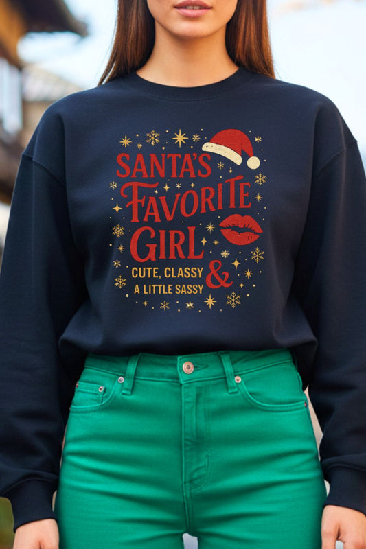 close up of a woman wearing a black oversized sweatshirt with 'Santa's Favorite Girl' text and green pants.