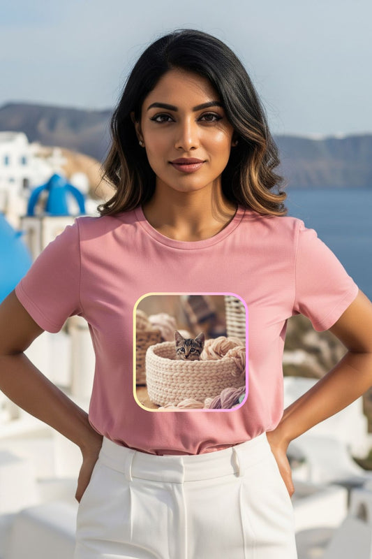 ZUPPI's "Your Daily Dose of Cuteness" light baby pink t-shirt with a graphic of a cute cat in a basket, worn by a woman outdoors.