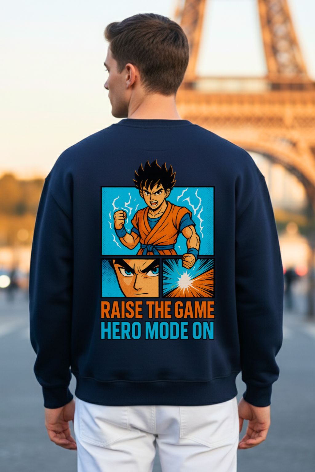 Back view of a man wearing a navy blue oversized sweatshirt with a graphic design and text in front of the Eiffel Tower.