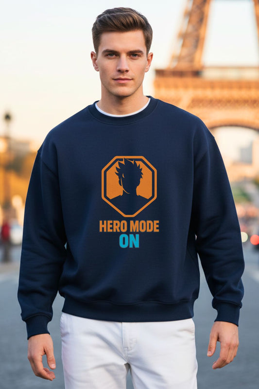 Front view of a man wearing a navy blue oversized sweatshirt with 'Hero Mode On' text and logo in front of the Eiffel Tower.