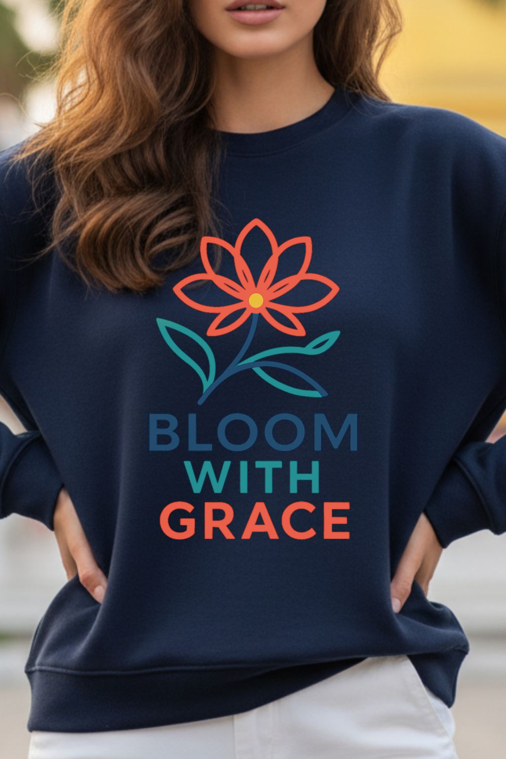 close up of a navy blue oversized sweatshirt with a floral design and 'Bloom with Grace' text worn by a woman.