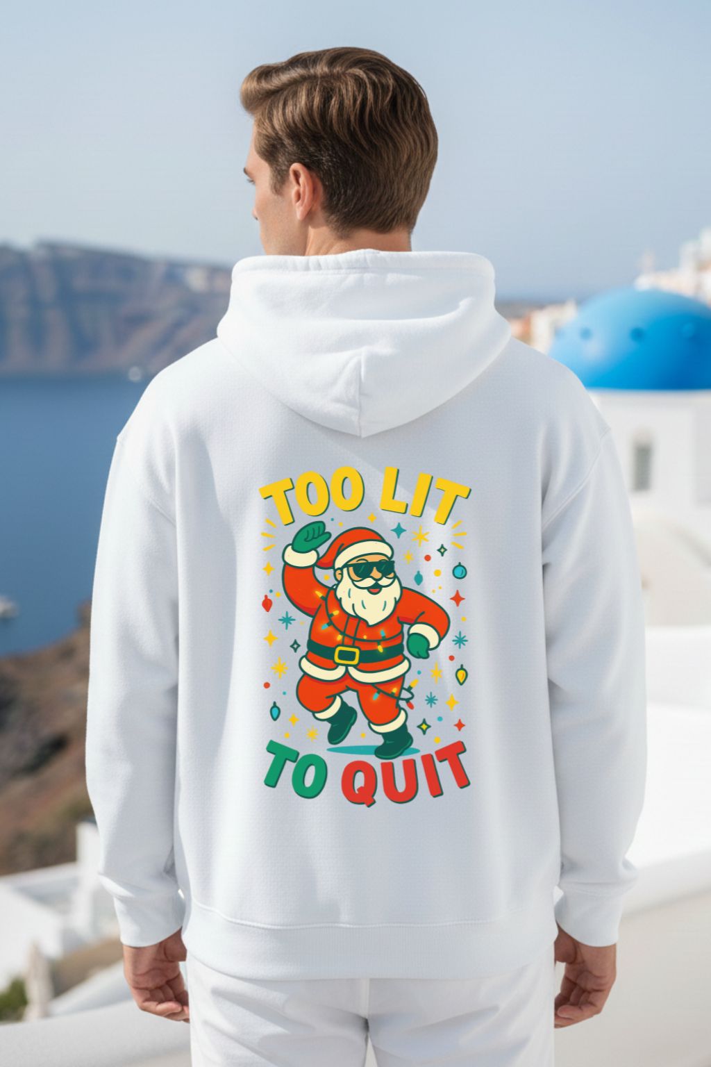 Person wearing a white oversized hoodie with a colorful graphic and text, standing in a scenic location.