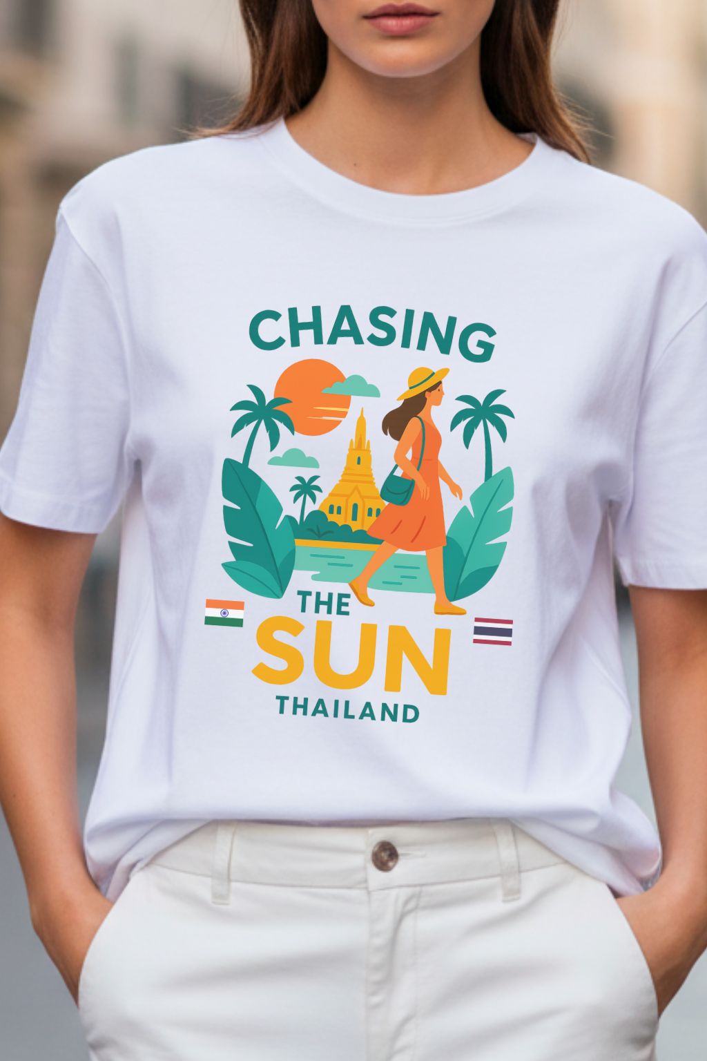 close up of a white oversized t-shirt with 'Chasing the Sun Thailand' graphic worn by a person.