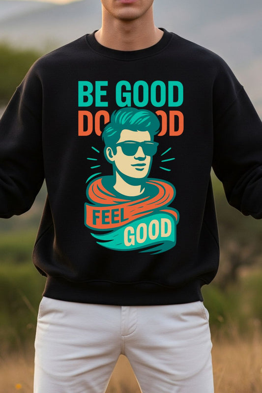 close up of a man wearing a black oversized sweatshirt with a colorful graphic and text 'Be Good Do Good Feel Good' in an outdoor setting.