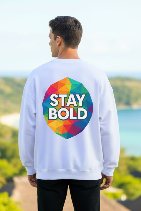 Back view of a man wearing a white oversized sweatshirt with 'Stay Bold' design outdoors