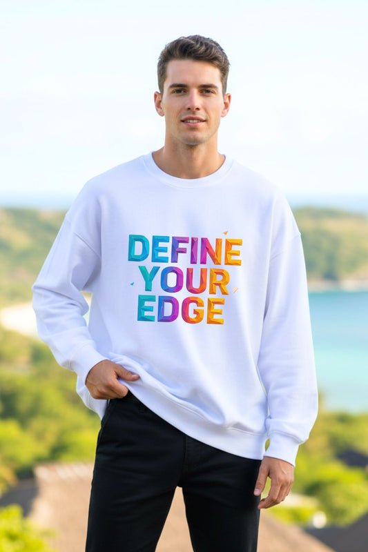 front view of a man wearing a white oversized sweatshirt with 'Define Your Edge' text in colorful letters, standing outdoors.