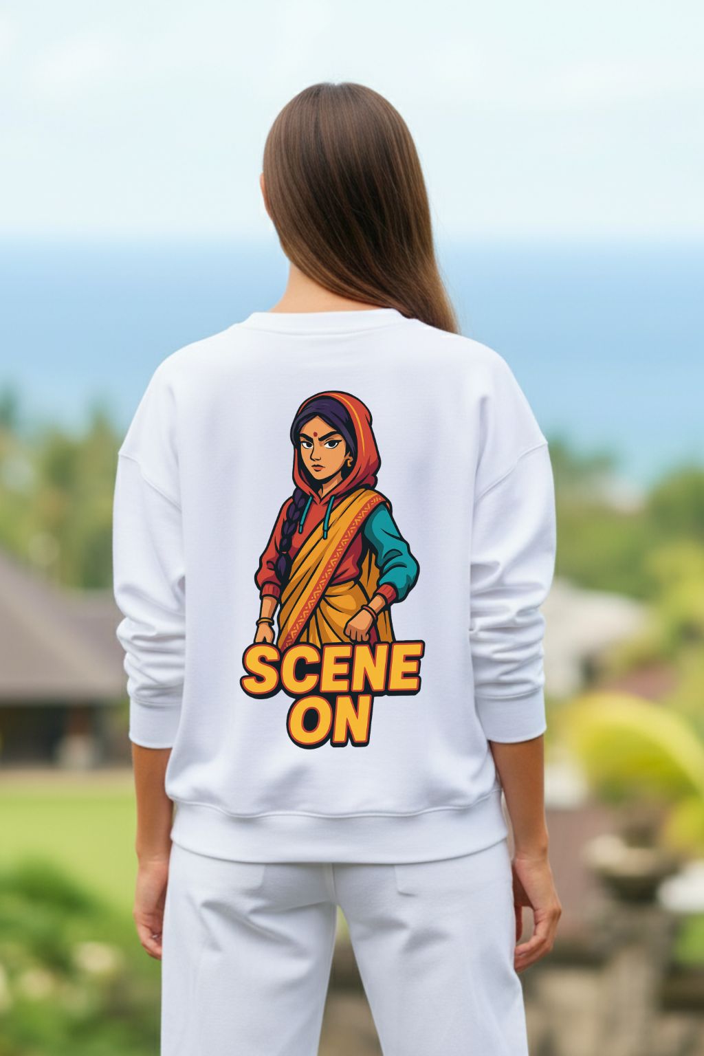 Woman wearing a white sweatshirt with a graphic design and text 'SCENE ON' outdoors.