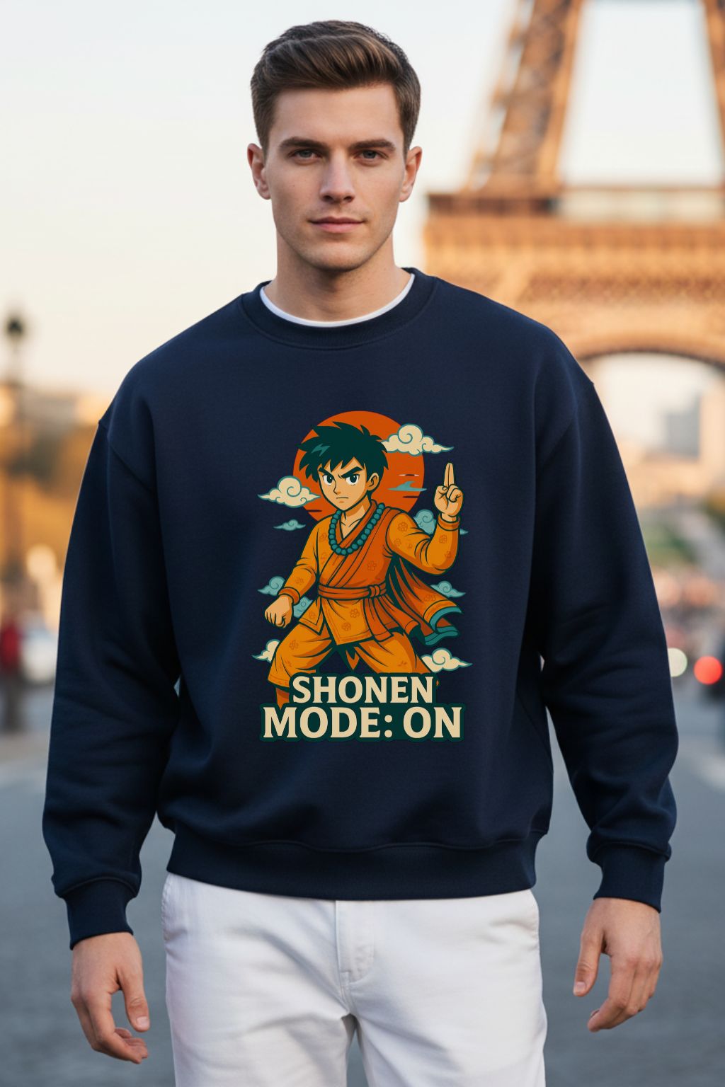 Man wearing a navy blue oversized  sweatshirt with a graphic design and text, standing in front of the Eiffel Tower.