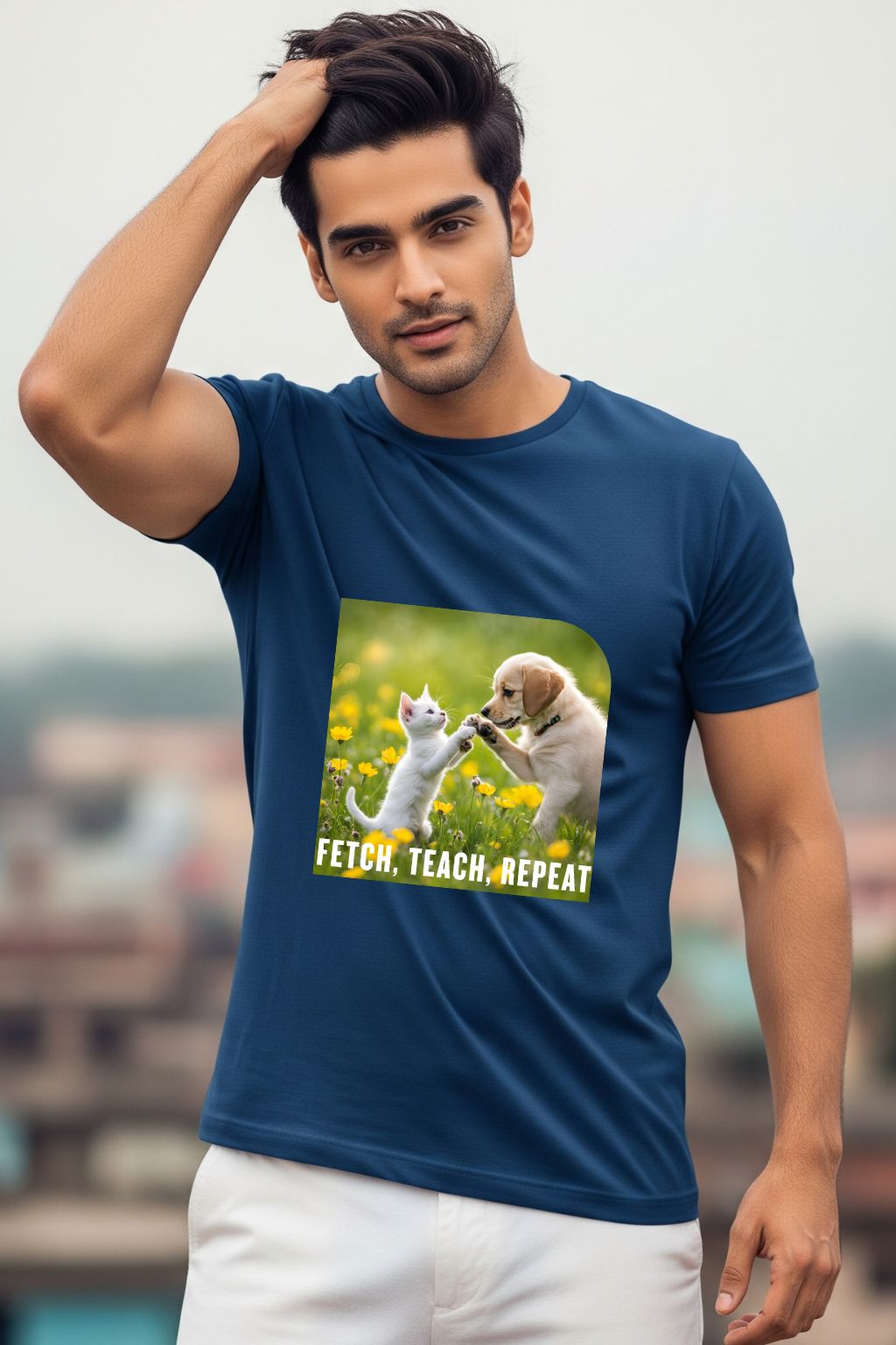 ZUPPI's "Fetch, Teach, Repeat" royal blue t-shirt, featuring a graphic of a dog and a cat, worn by a man against a mountainous background.