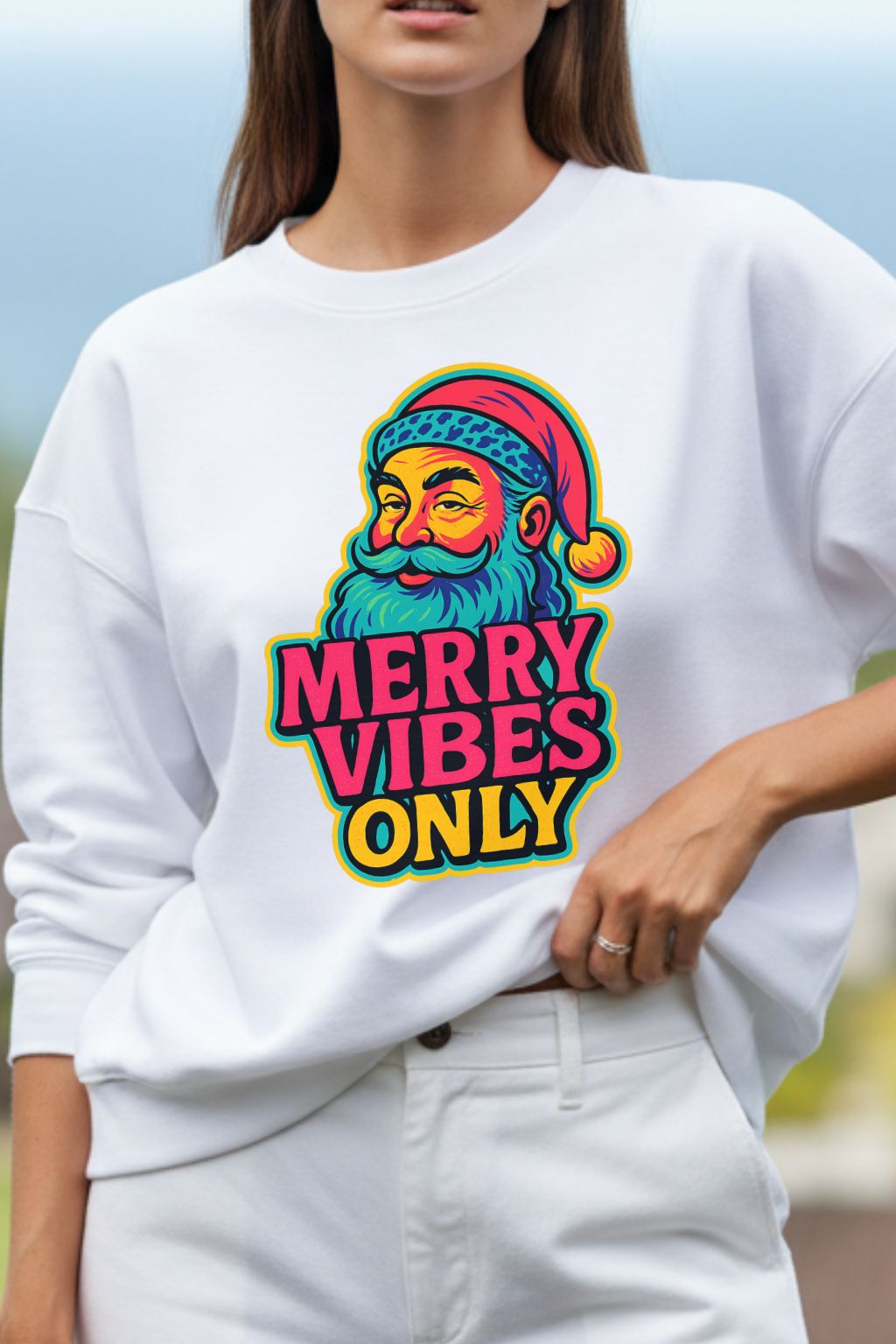 close up of a woman wearing a white oversized sweatshirt with a colorful graphic and text 'Merry Vibes Only'.