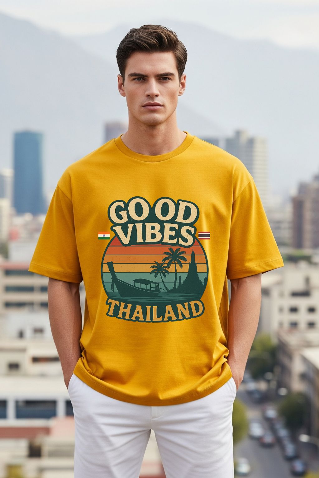 Man wearing a golden yellow oversized t-shirt with 'Good Vibes Thailand' design in an urban setting