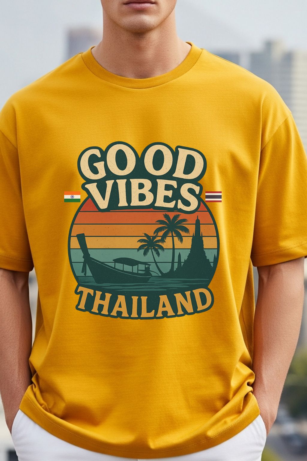 close up of a man wearing a golden yellow oversized t-shirt with 'Good Vibes Thailand' graphic design.