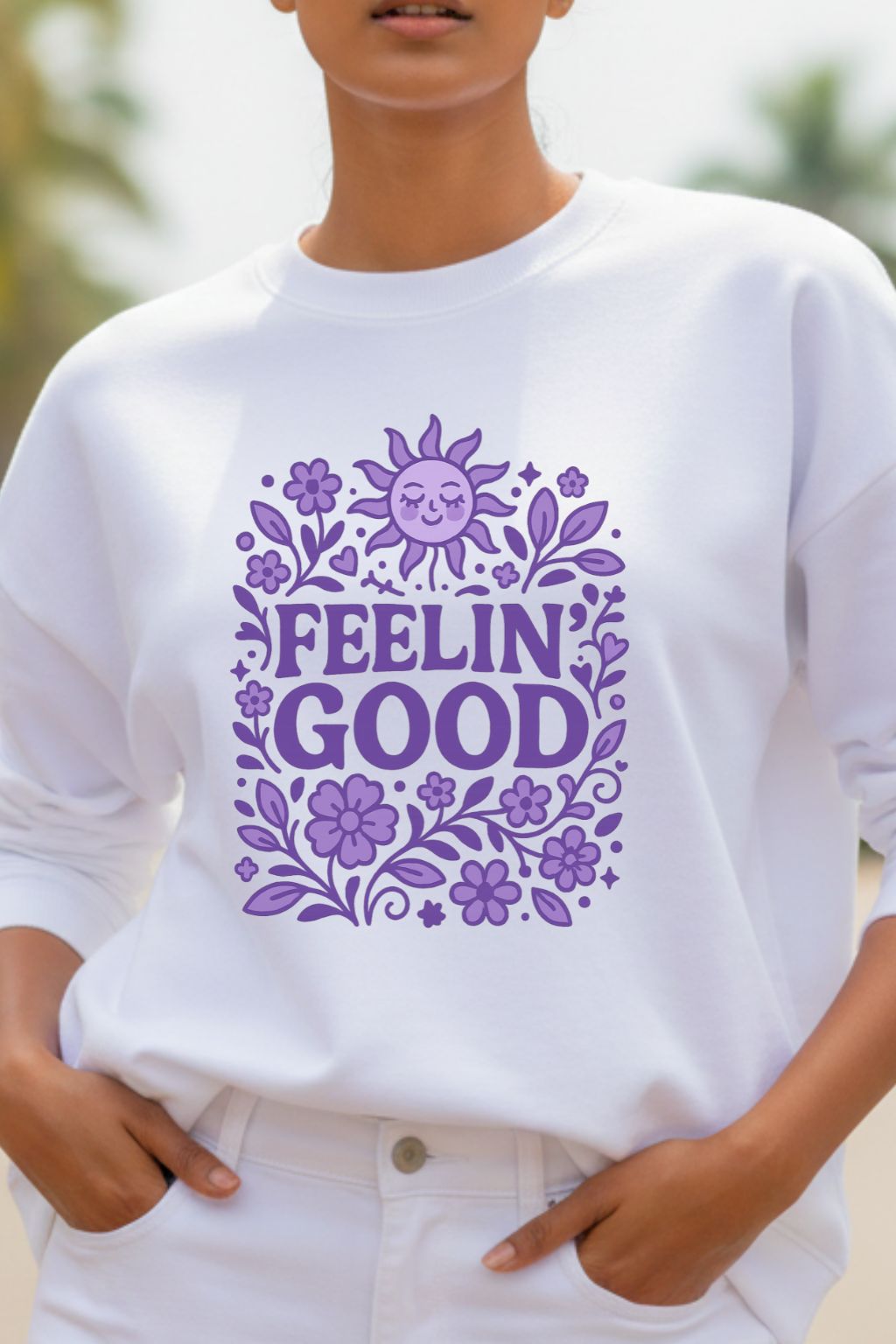 close up of a woman wearing a white oversized sweatshirt with purple floral design and 'FEELIN' GOOD' text.