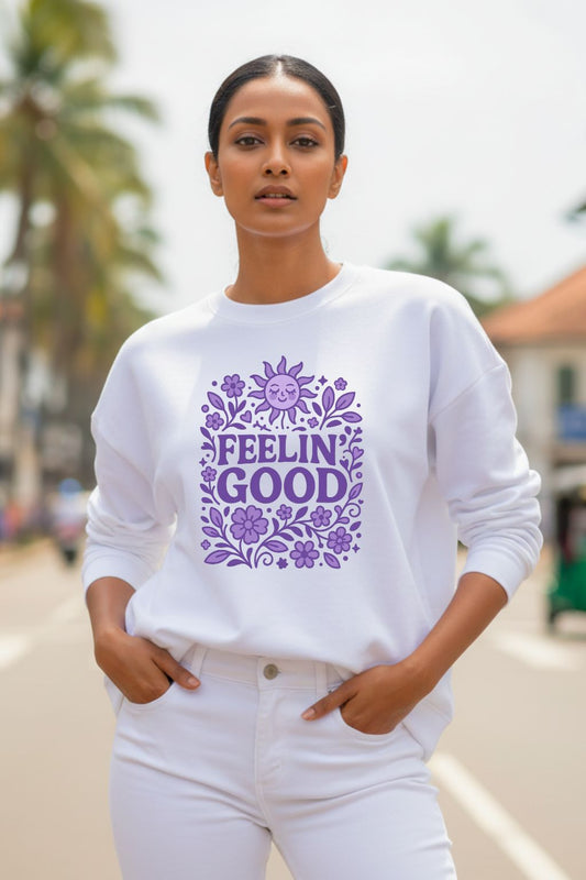 Woman wearing a white oversized sweatshirt with purple text and floral design outdoors.