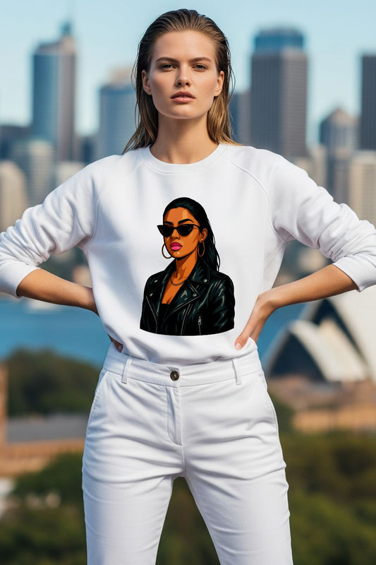 Woman wearing a white sweatshirt with a graphic design of a woman in a leather jacket against a city skyline.