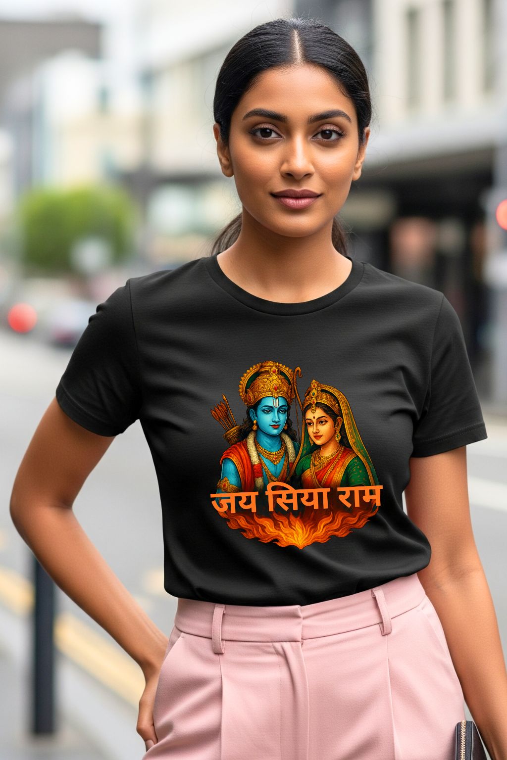 Woman wearing a black t-shirt with a colorful graphic and text, standing on a street.