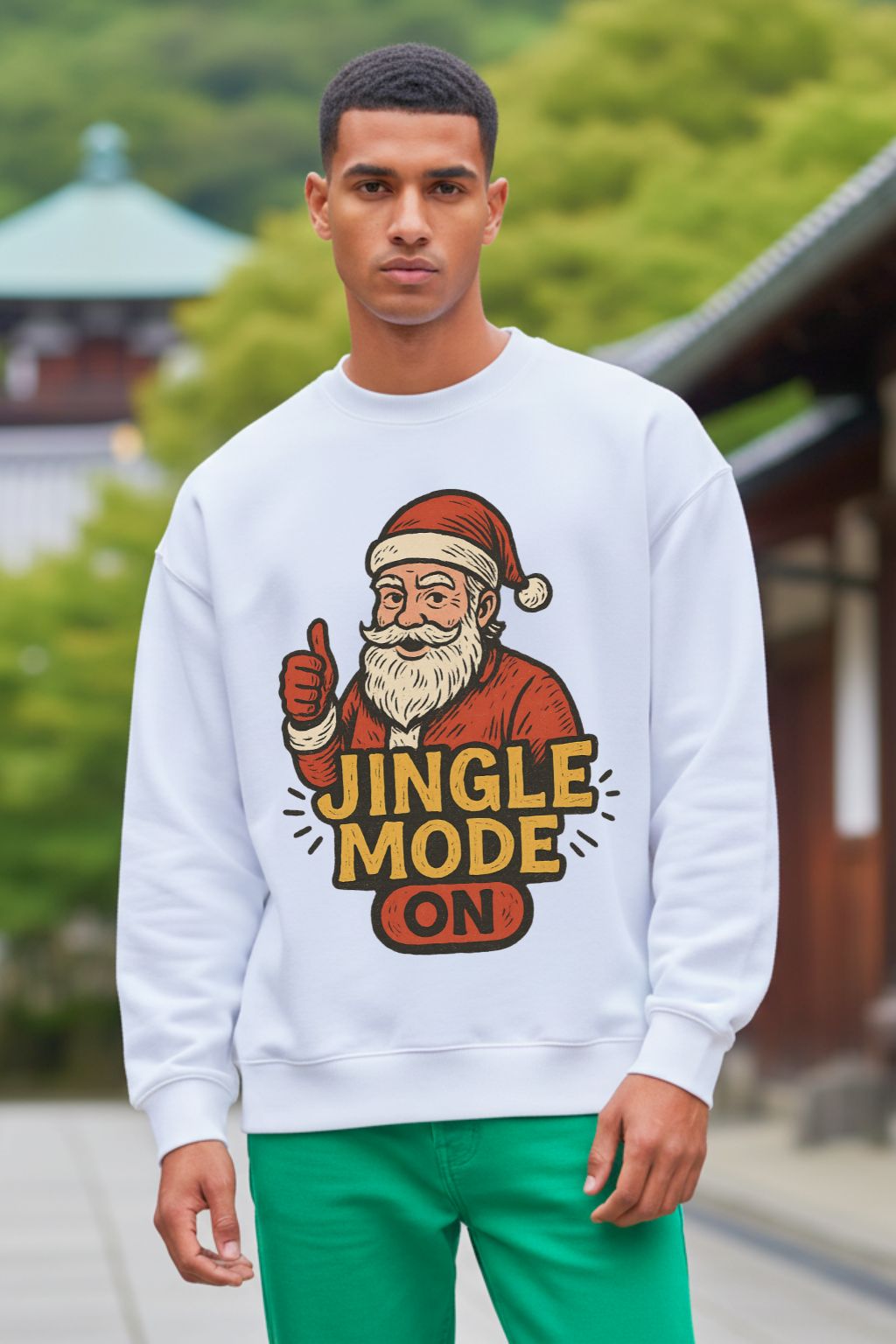 Man wearing a white oversized sweatshirt with a Santa Claus graphic and 'Jingle Mode On' text in an outdoor setting.