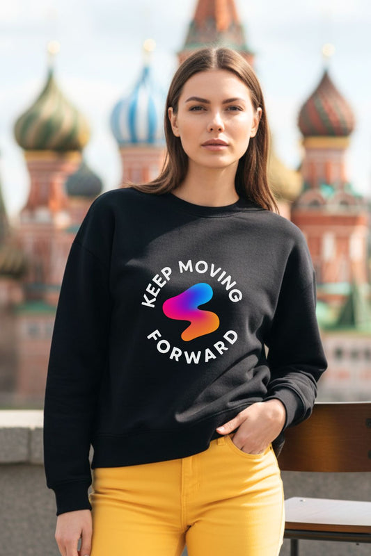 Woman wearing a black oversized sweatshirt with a colorful logo and text, standing in front of a blurred cityscape.
