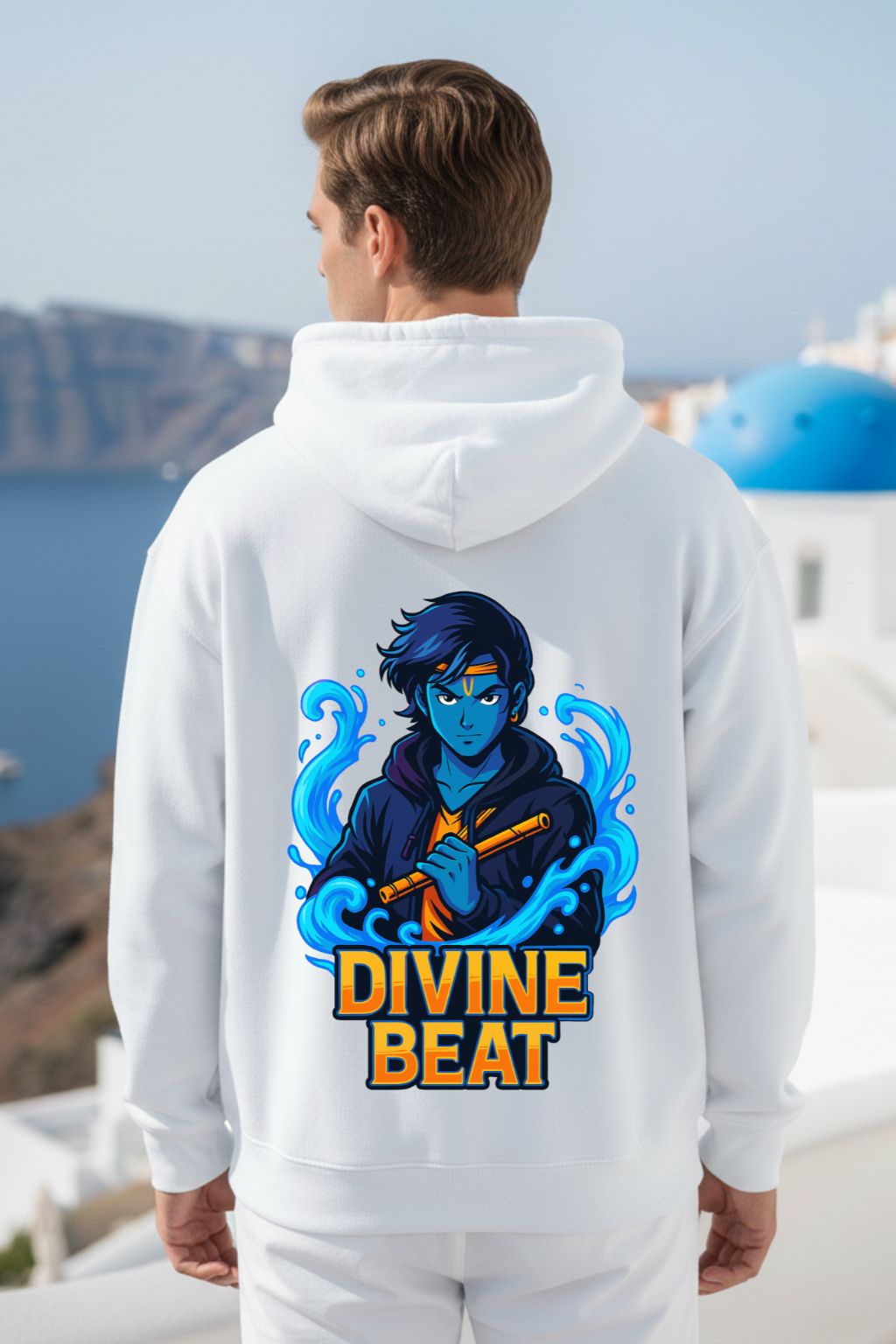 Man wearing a white oversized hoodie with a lord krishna design on the back, set against a scenic background.