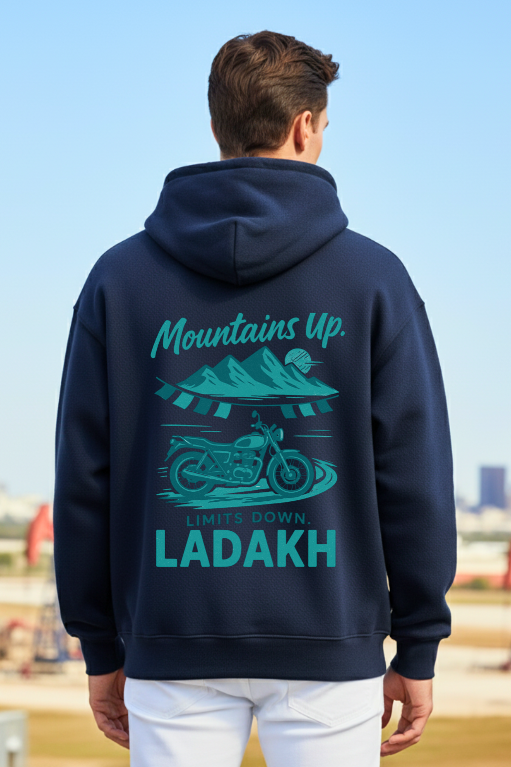 back view of a man wearing a navy blue oversized hoodie with 'Mountains Up, Limits Down, Ladakh' text and graphic.
