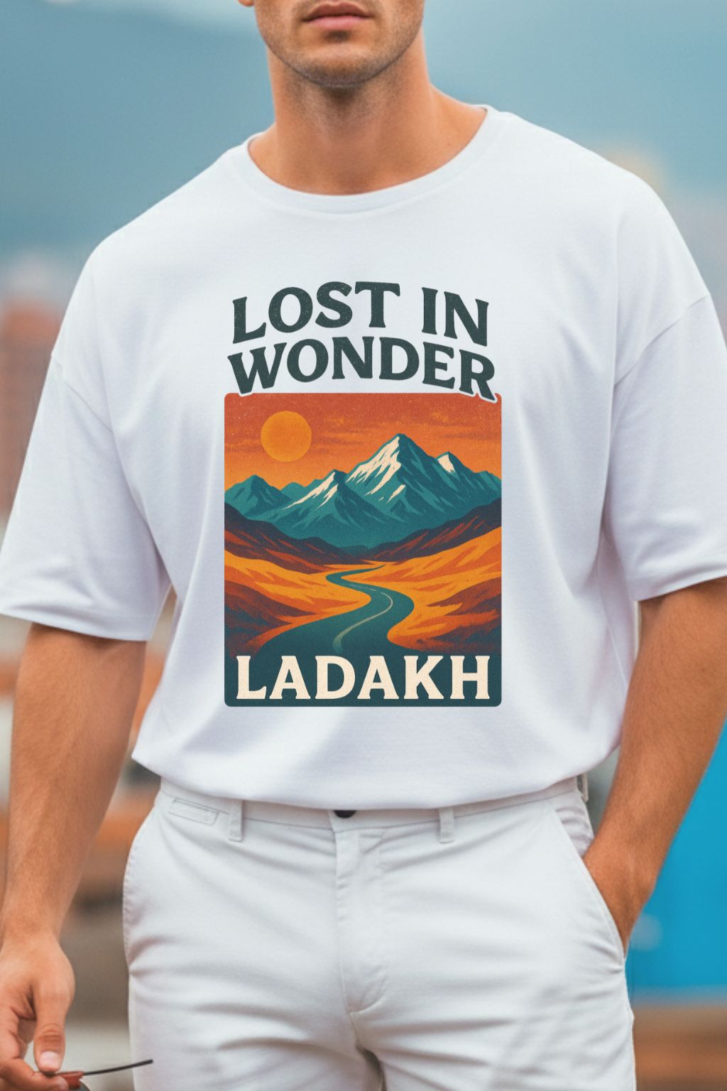close up of a man wearing a white oversized t-shirt with 'Lost in Wonder Ladakh' design.