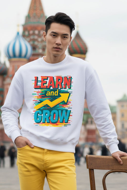 Man wearing a white oversized sweatshirt with colorful text 'LEARN and GROW' in an urban setting.