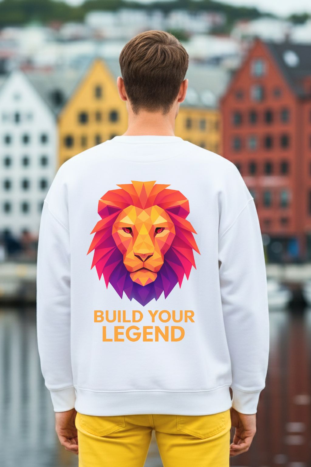 back view of a man wearing a white oversized sweatshirt with a colorful lion graphic and 'Build Your Legend' text, standing in front of a cityscape.