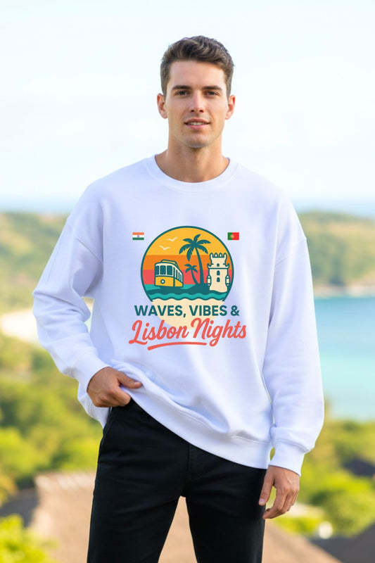 Man wearing a white oversized sweatshirt with a colorful graphic and text, standing outdoors with a scenic background.
