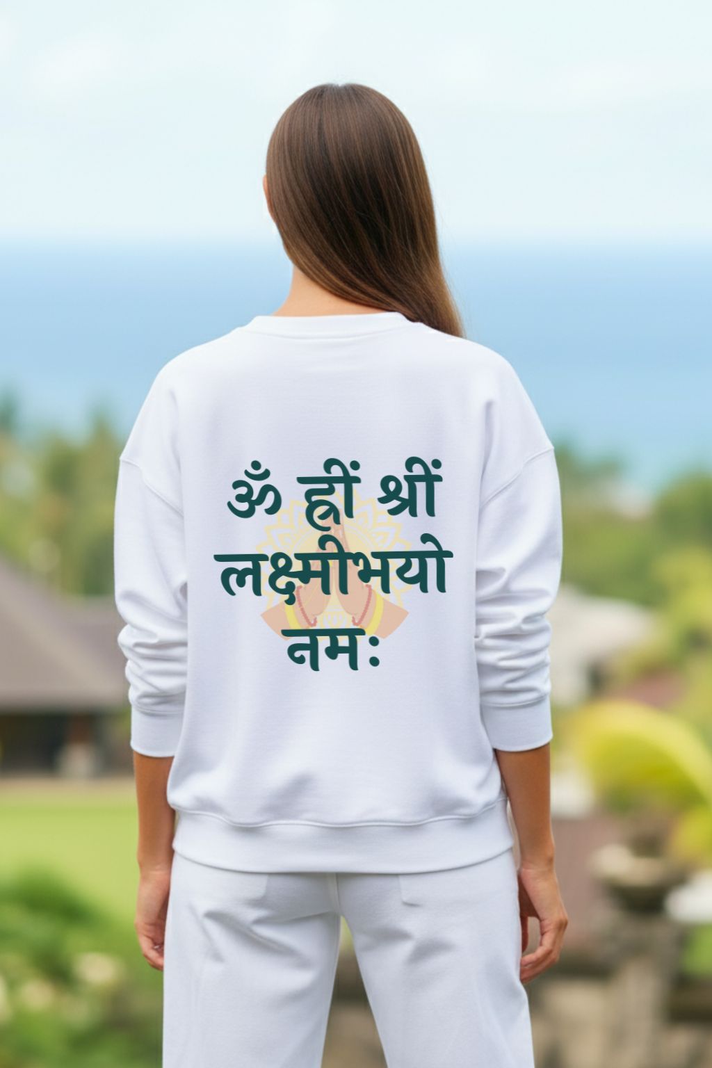 back view of a woman wearing a white oversized sweatshirt with lakshmi mantra outdoors