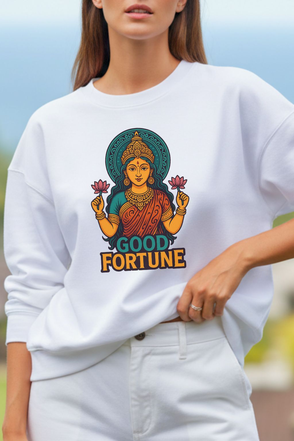 close up of a woman wearing a white oversized  sweatshirt with a colorful 'Good Fortune' design.