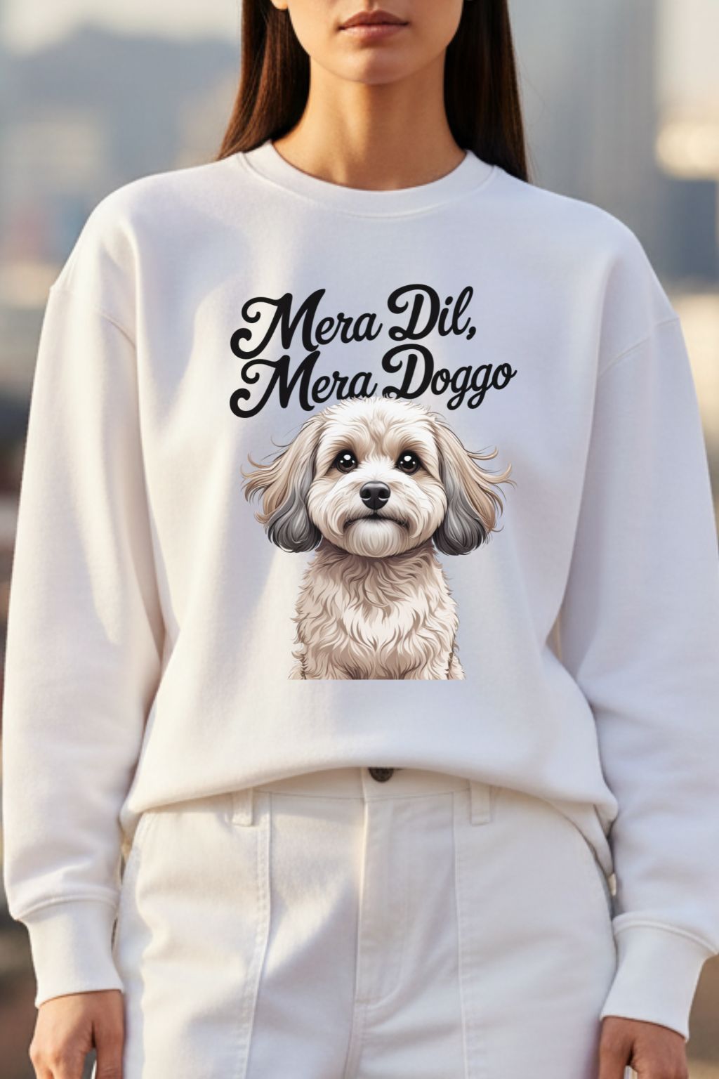 close up of a woman wearing a white oversized sweatshirt with a dog illustration and text in a blurred outdoor setting