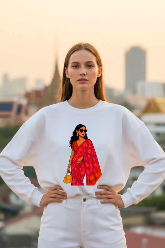 Woman wearing a white sweatshirt with a graphic of a woman in a red saree against a cityscape background.