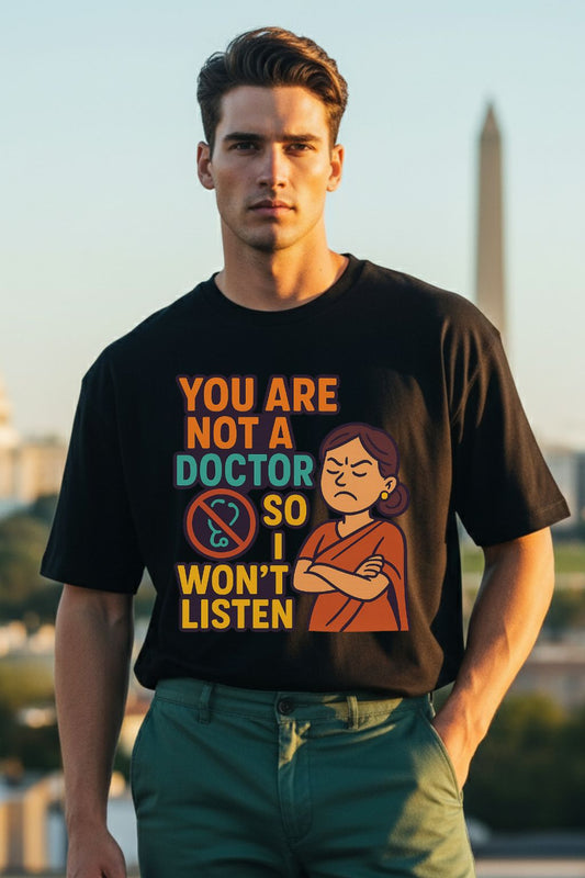 Man wearing a black t-shirt with a graphic and text, standing outdoors with a blurred background