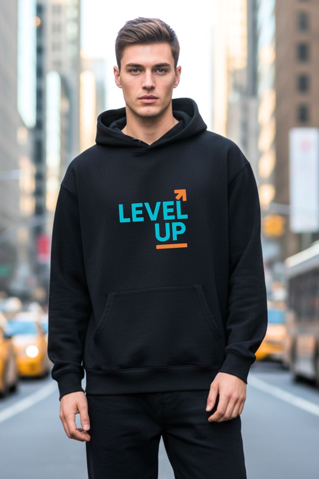 Front view of a man wearing a black oversized  hoodie with 'LEVEL UP' text on a city street