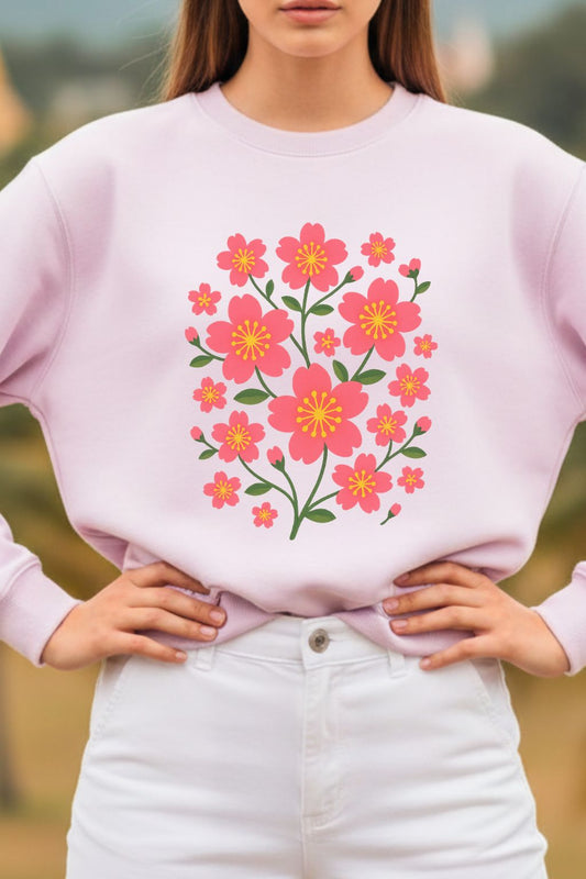 close up of a woman wearing a light pink oversized sweatshirt with a floral design outdoors