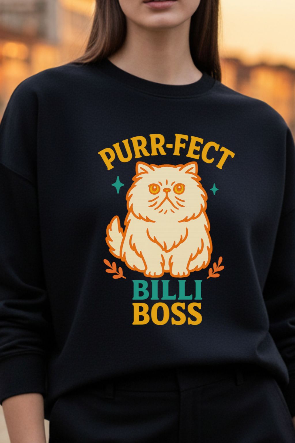 Woman wearing a black sweatshirt with a cat graphic and text 'Purr-fect Billi Boss'.