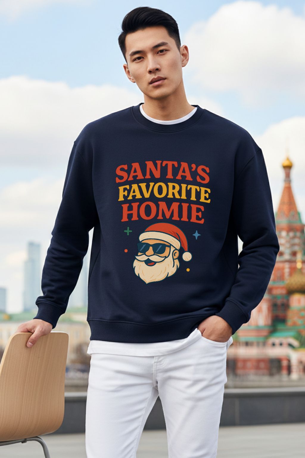 Man wearing a navy blue oversized sweatshirt with 'Santa's Favorite Homie' text and graphic, standing outdoors.