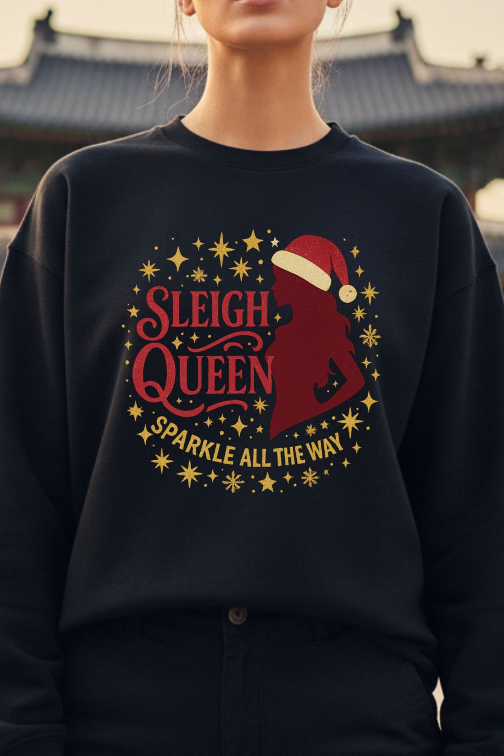 close up of a woman wearing a black oversized sweatshirt with 'Sleigh Queen Sparkle All the Way' design.