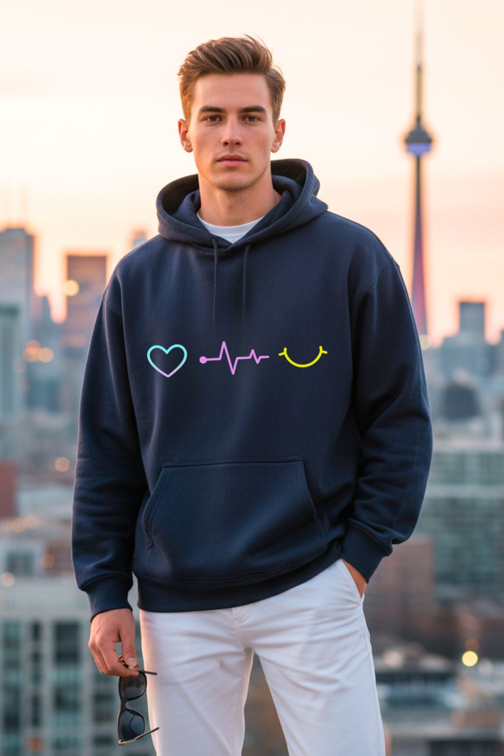 front view of a man wearing a navy blue oversized hoodie with colorful designs against a cityscape background