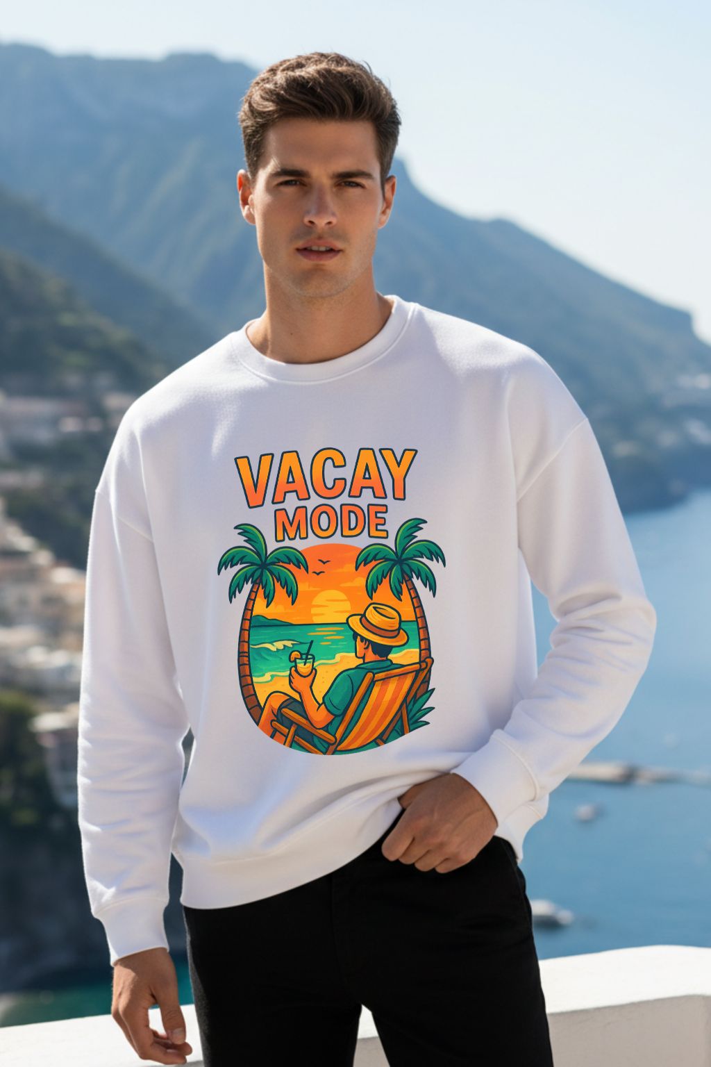 Man wearing a white sweatshirt with 'Vacay Mode' design by a scenic mountain and water background