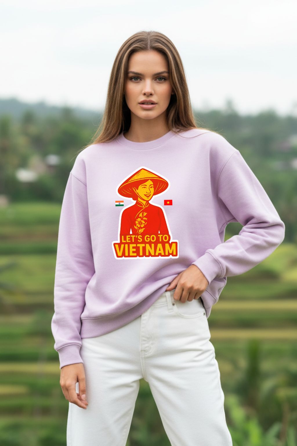 Woman wearing a light baby pink oversized sweatshirt with a graphic design and text, standing outdoors.