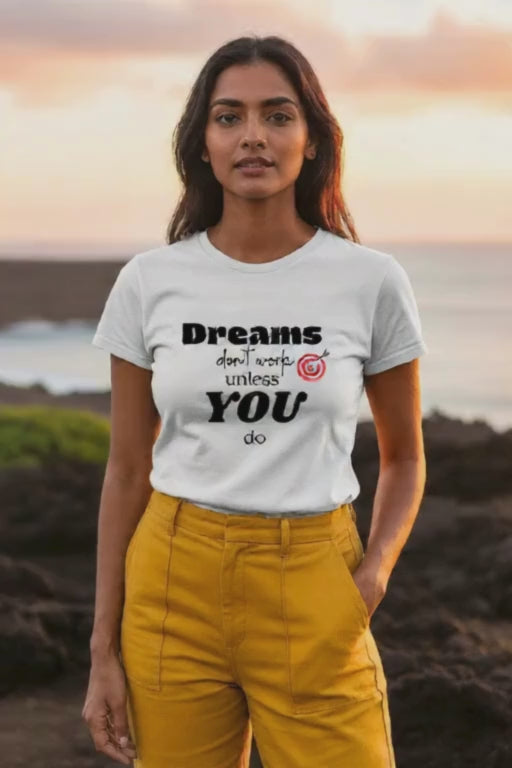A model showcasing the "Dreams don't work unless you do" white t-shirt, with the text clearly visible.